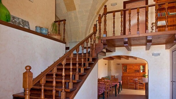 Un escalier en bois, doté d’une balustrade, mène à un niveau supérieur.