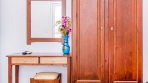 A wooden desk with a vase of flowers, a mirror, and a wardrobe. - Kalyves Bay (Apokoronas)