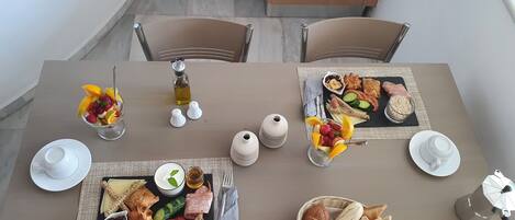 A dining table set with various food items, including fruits, bread, and condiments.