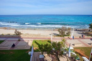 En la playa, arena blanca, sillas reclinables de playa, sombrillas