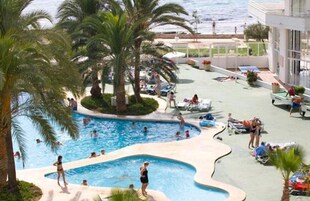 Una piscina al aire libre, sombrillas, sillones reclinables de piscina