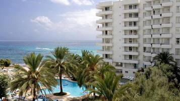 Een buitenzwembad, parasols bij het zwembad en ligstoelen