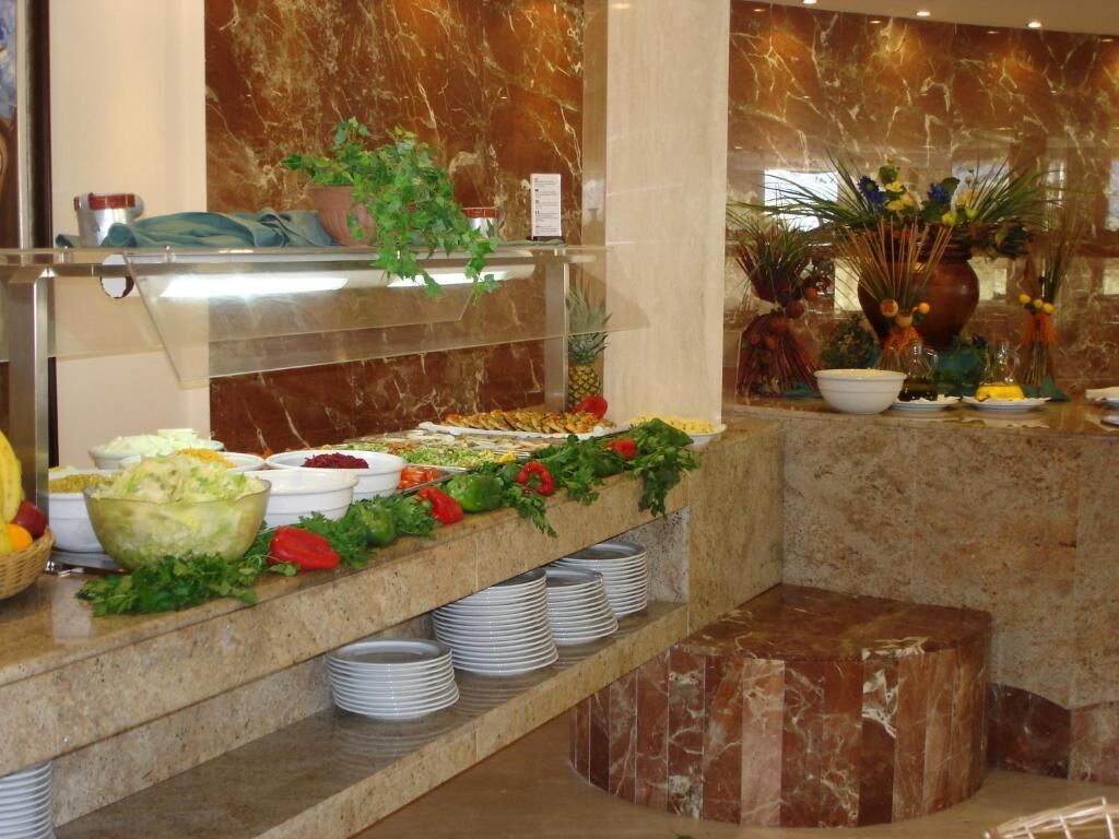 Un bufé con diversos alimentos y un arreglo floral decorativo.