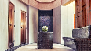 A spacious lobby with a circular floor plan, a central decorative column, and a seating area with a patterned sofa. - ETO Park Hotel Business & Stadium (Gyor)