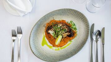 Une assiette de nourriture avec une fourchette et un couteau posés sur une table.