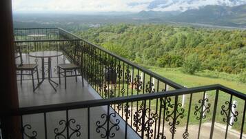 A balcony with a view of a mountainous landscape.