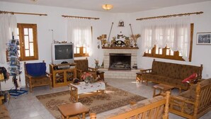 Un salón acogedor con chimenea, muebles de madera y televisor.