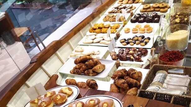 Un bufé con diversas opciones de panadería, incluyendo pasteles, pan y postres.
