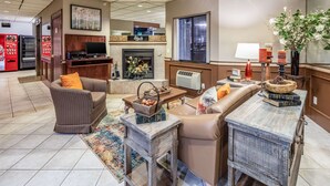 A modern living room with a fireplace, comfortable seating, a coffee table, and a TV. - Quality Inn Keystone near Mount Rushmore (Keystone)