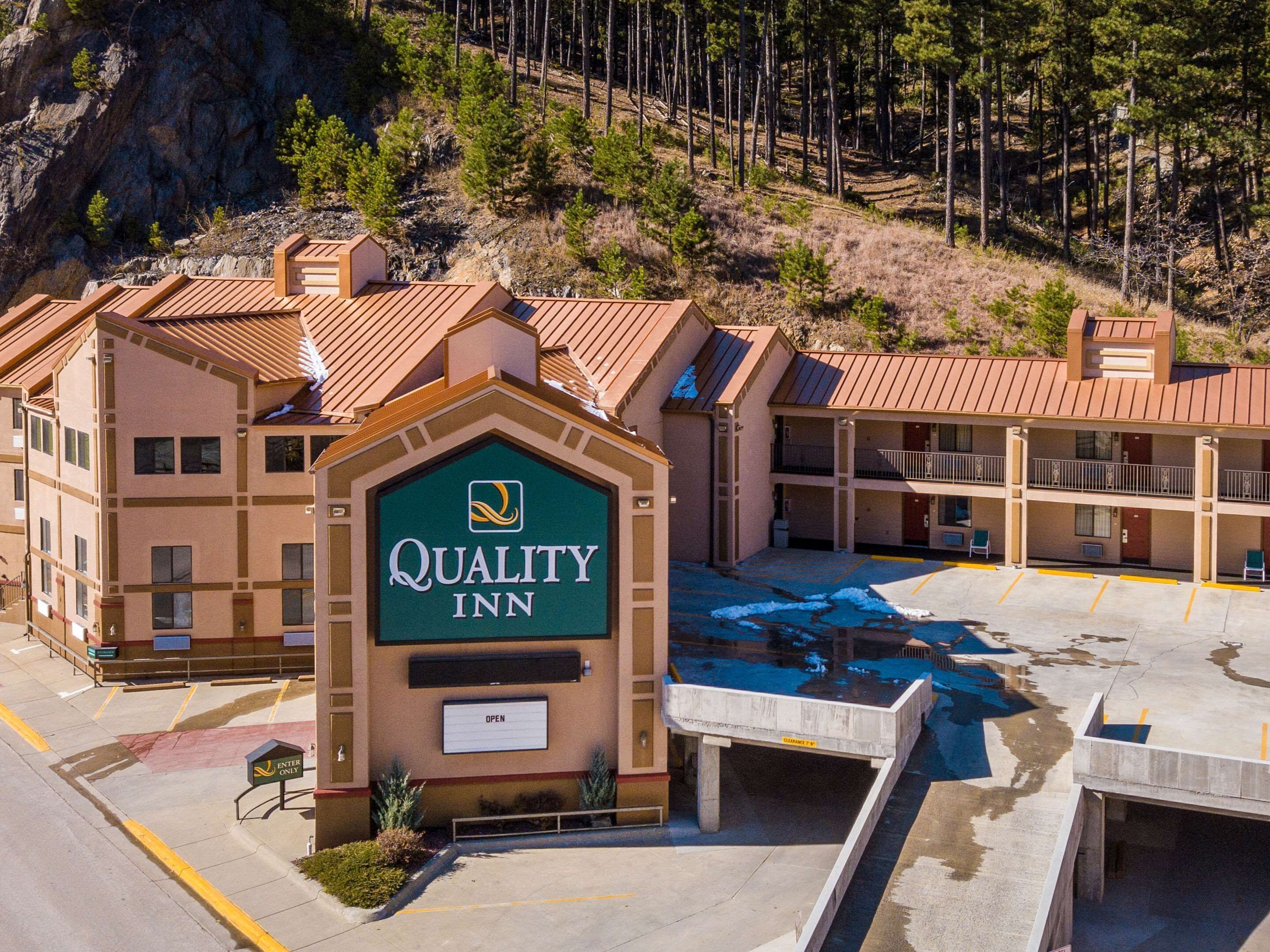 Un Quality Inn con un letrero grande, varios pisos y un estacionamiento.
