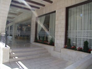 A building entrance with a set of stairs leading up to a door with a decorative glass panel.