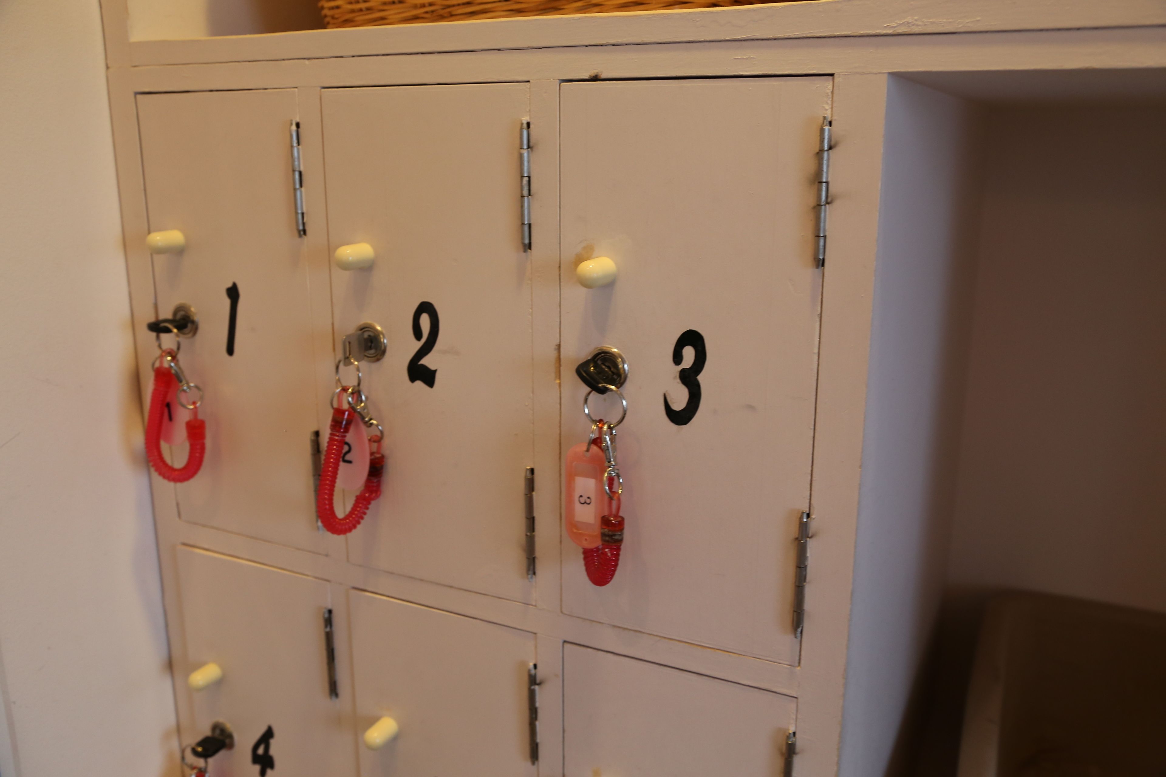 A row of numbered lockers with keys and keychains.