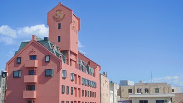 Un hotel rosa con una torre destacada y numerosas ventanas.