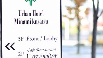 A hotel sign with the Urban Hotel Minami kusatsu name, indicating a 3F Front/Lobby and a 2F Cafe Restaurant Lavender.
