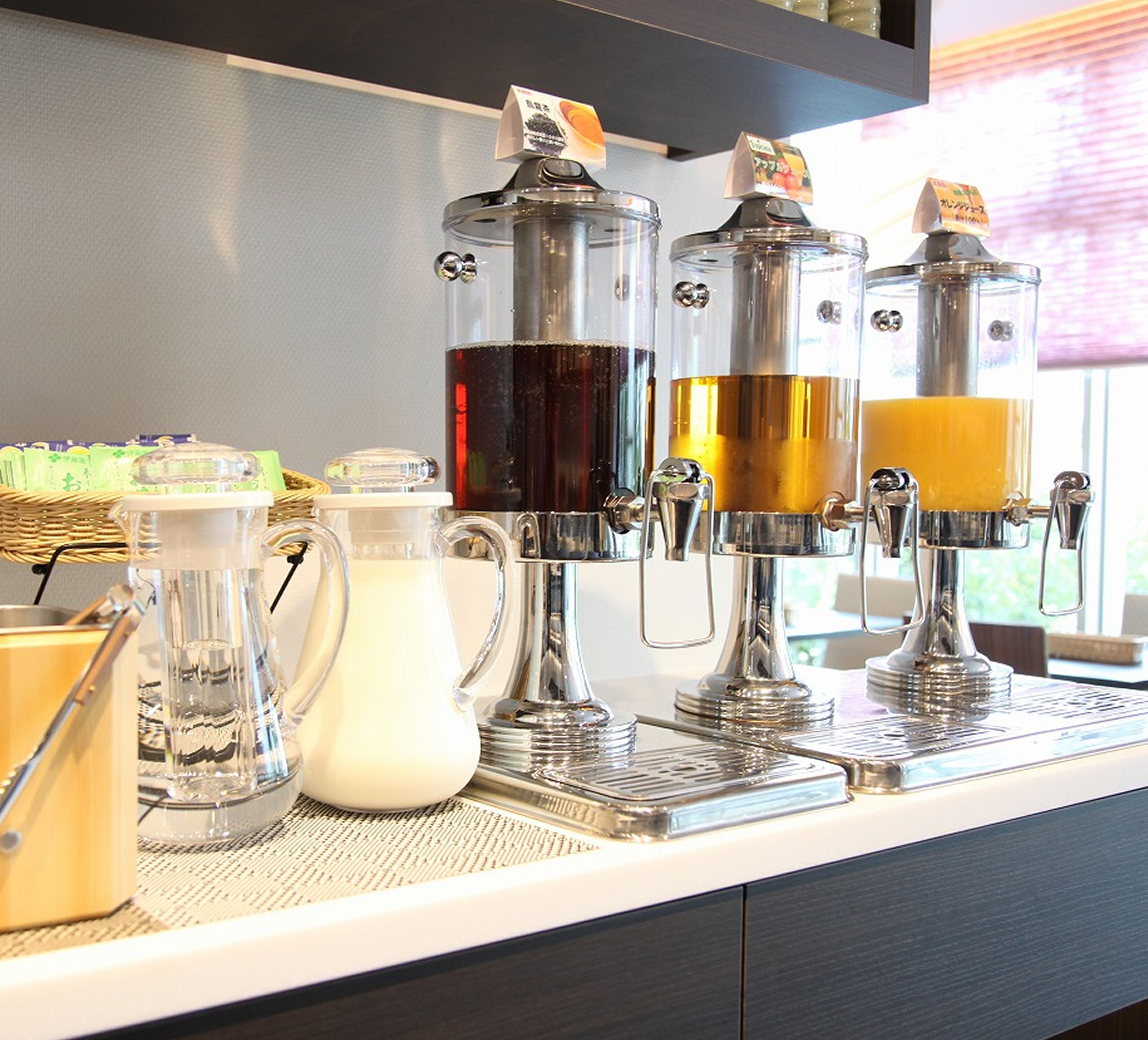 Een koffiehoek met meerdere koffiehoeveelheden en een melkkan.