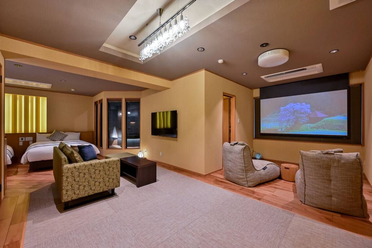 Une chambre d’hôtel équipée d’un lit, d’un canapé, d’une télévision et d’un écran de projection.