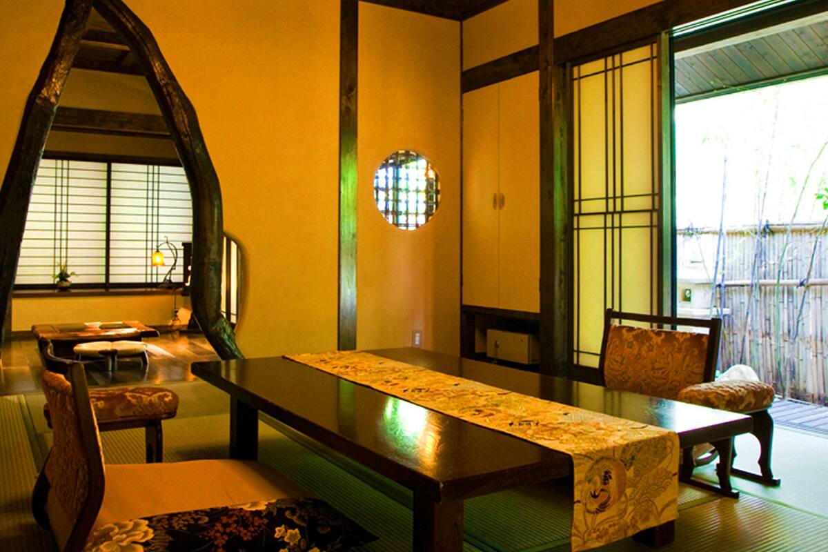 Une pièce de style japonais traditionnel, avec un sol recouvert de tatamis, une table basse et des portes coulissantes.