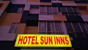 Un edificio con un letrero que dice "HOTEL SUN INNS".