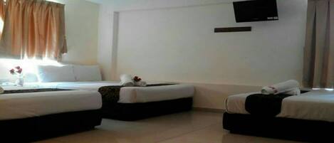 Quarto de hotel com duas camas, uma televisão de tela plana na parede e uma janela com cortinas.