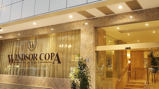 Exterior del Hotel Windsor Copa, con una fachada moderna, amplias ventanas y una entrada visible con una escalera.