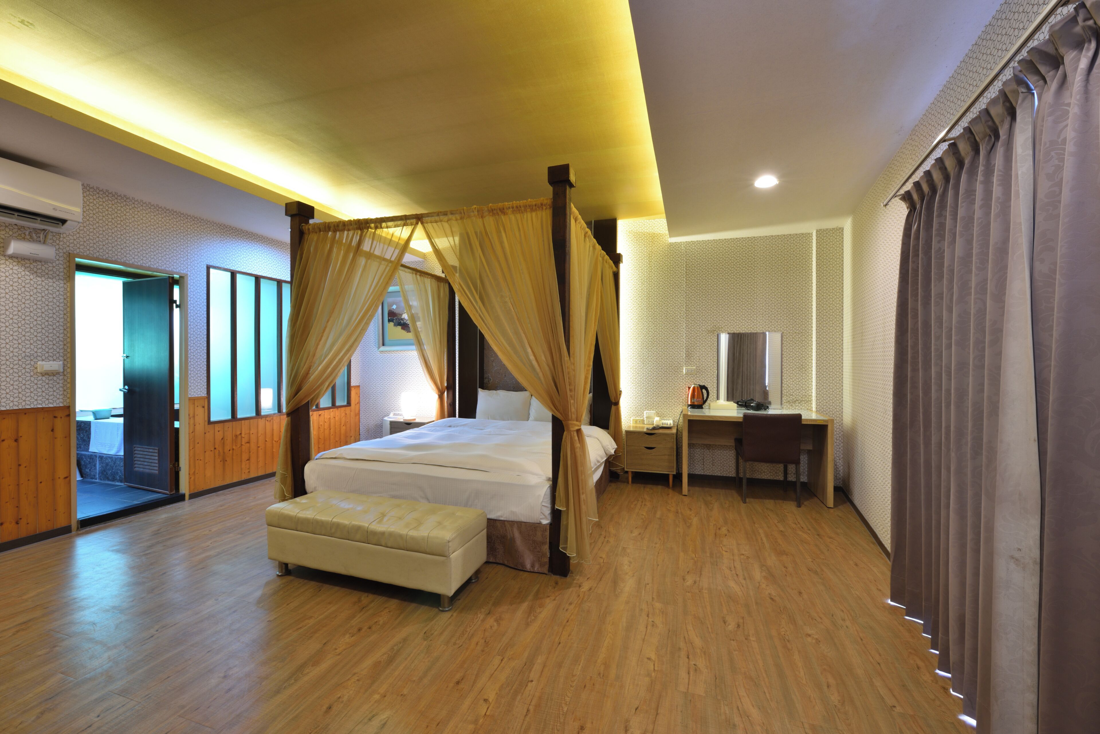 A bedroom with a four-poster bed, a desk with a chair, a television, and a window with curtains.