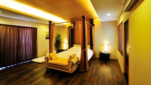 A four-poster bed in a hotel room with a wooden floor, a nightstand, and a lamp. - Cimengrou Hall (Dahu)