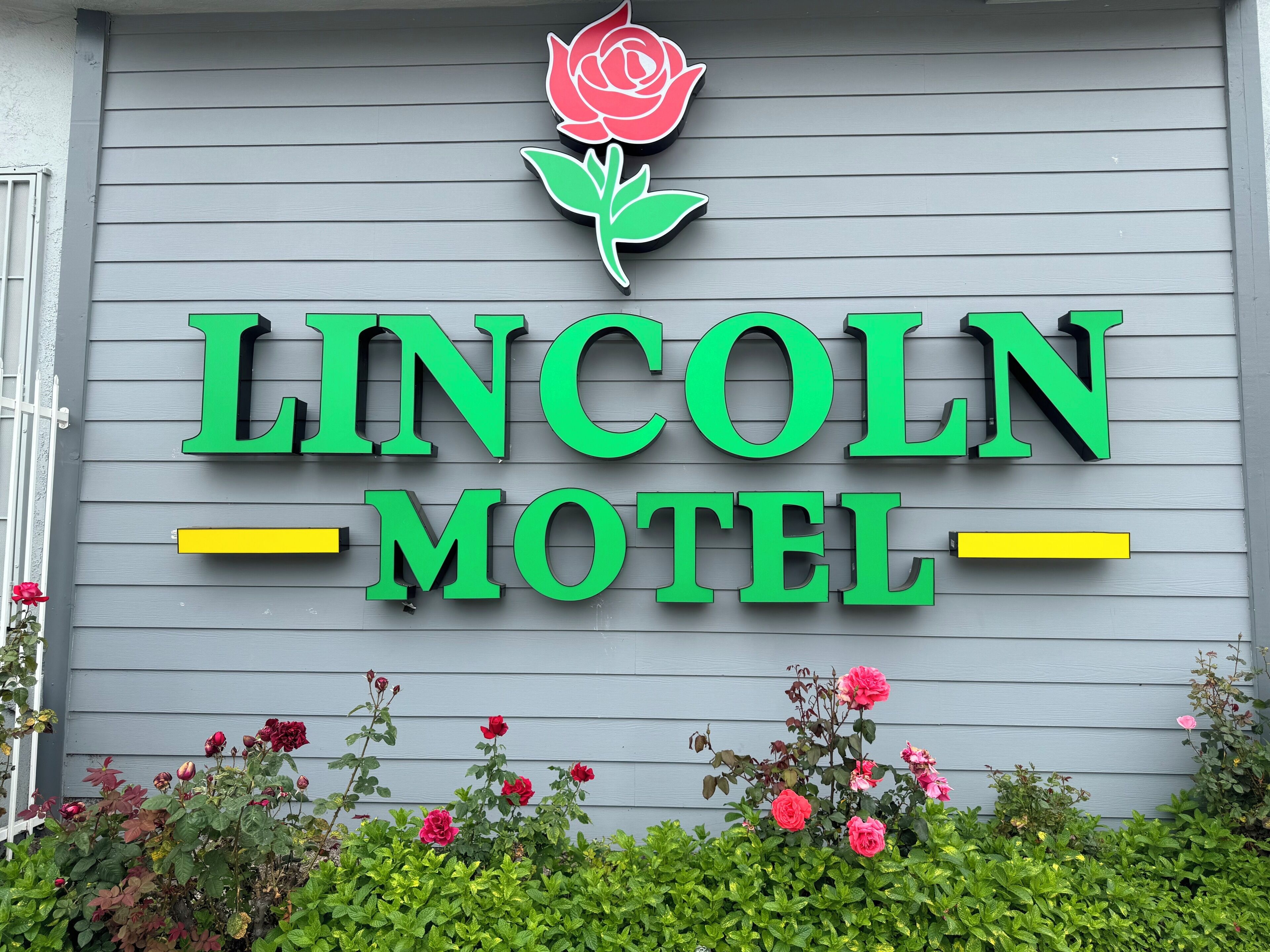 Un letrero de motel con un logotipo de rosa y el nombre 'LINCOLN MOTEL' en letras verdes.