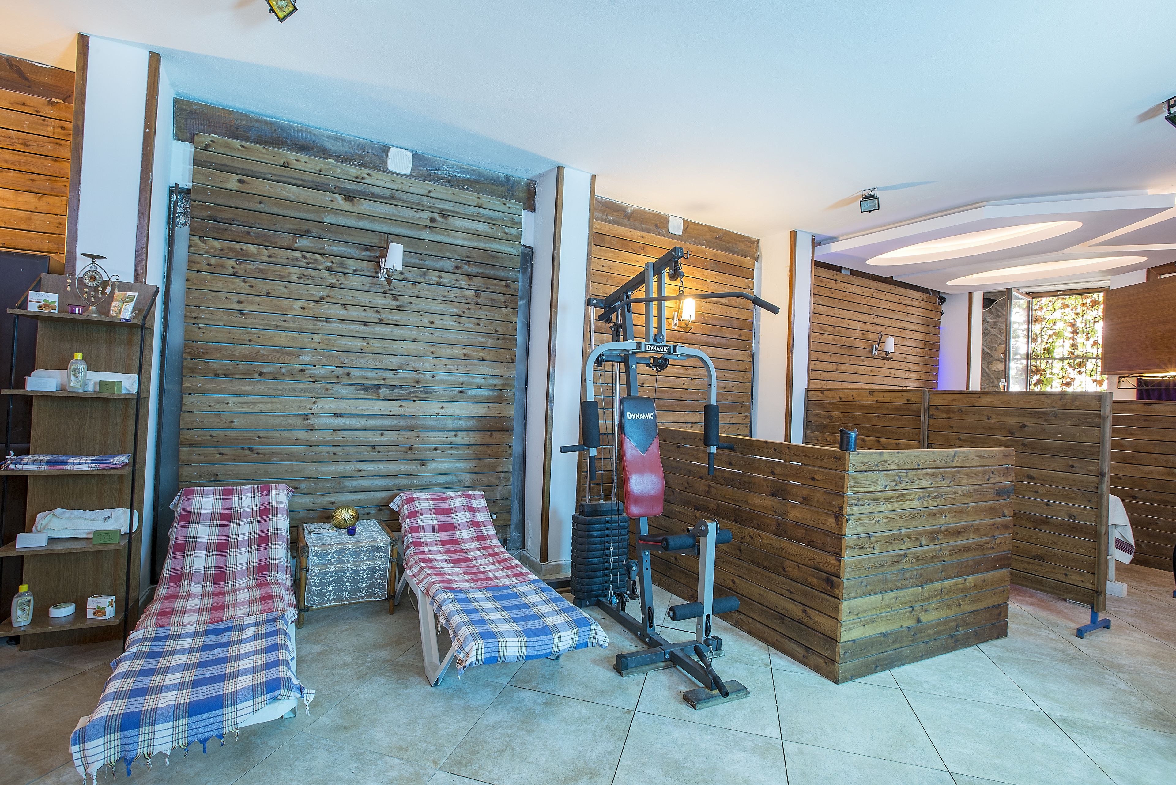 Een kamer met een bed, een bank en een fitnesshoek.