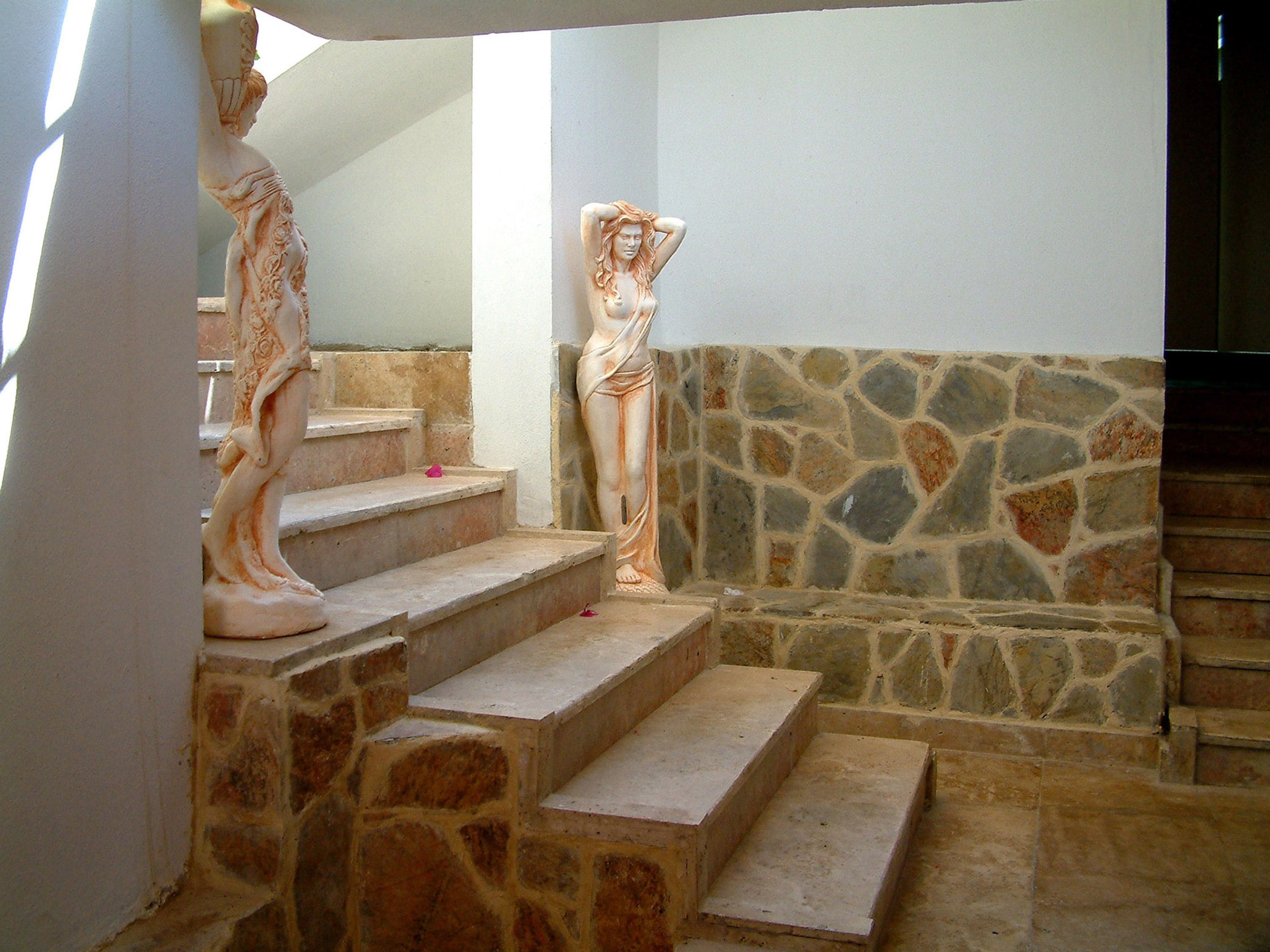 A staircase with stone steps and a stone wall.