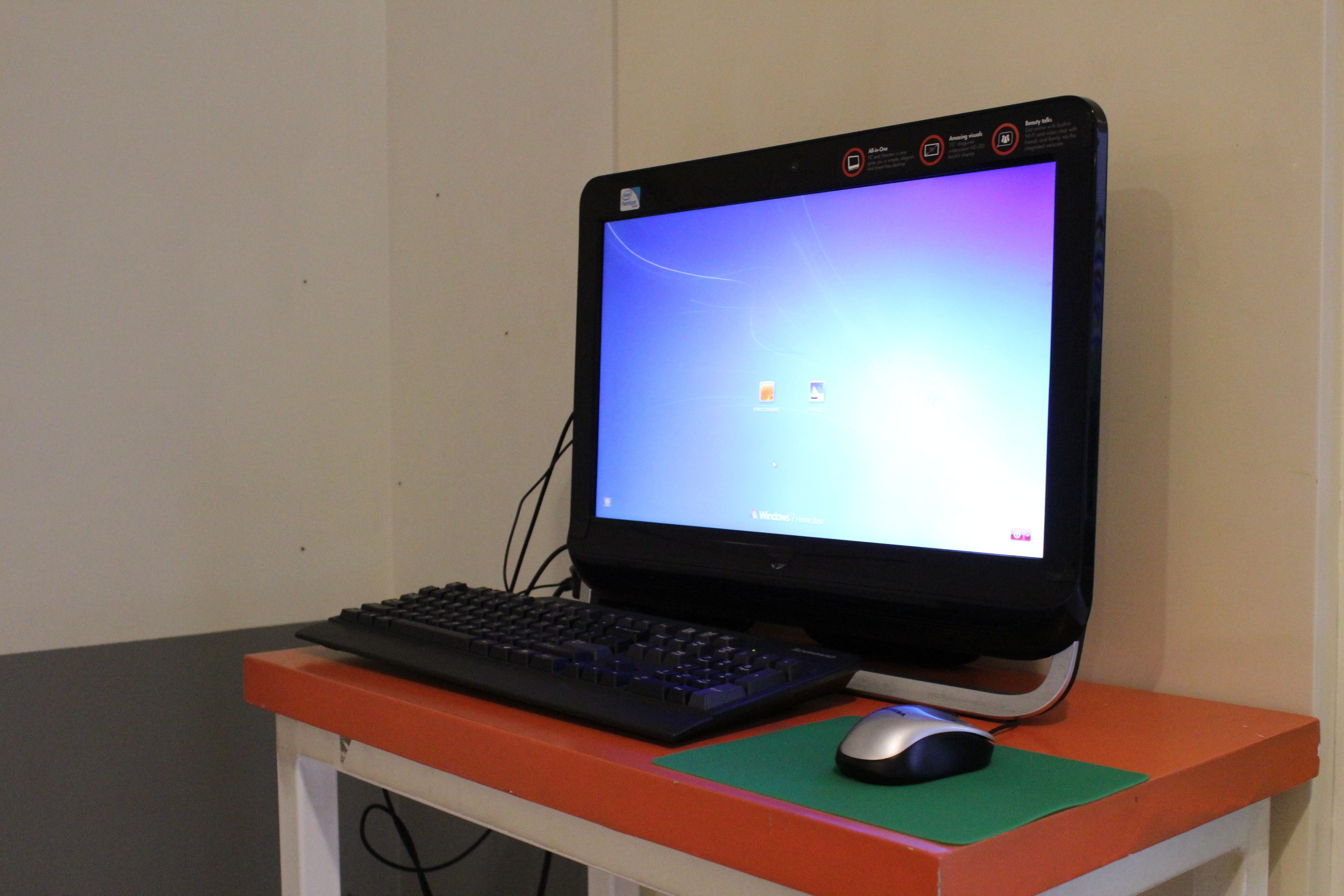 A computer setup with a monitor, keyboard, and mouse on a desk.