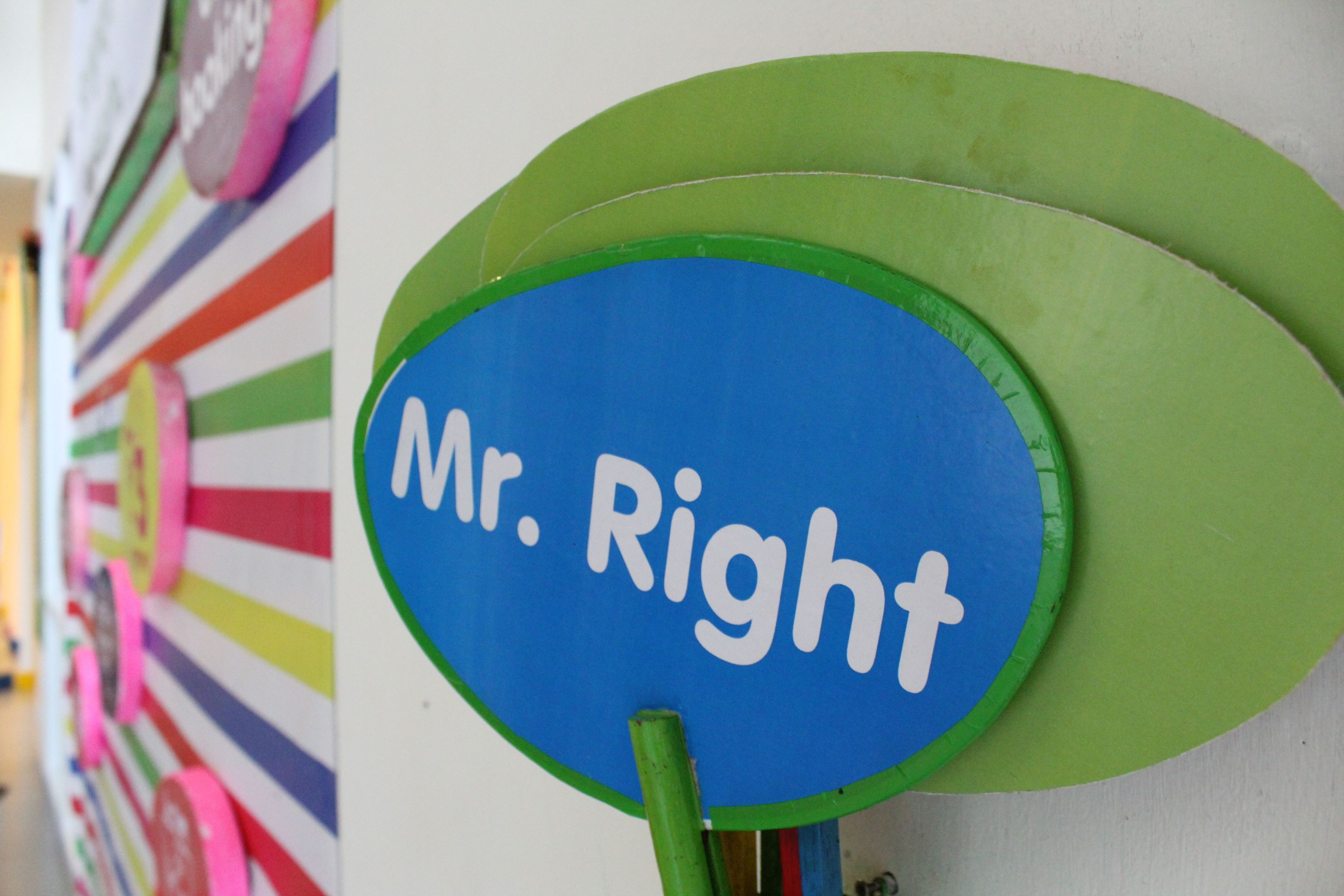 A wall with a sign that reads "Mr. Right" and colorful, striped decorations.