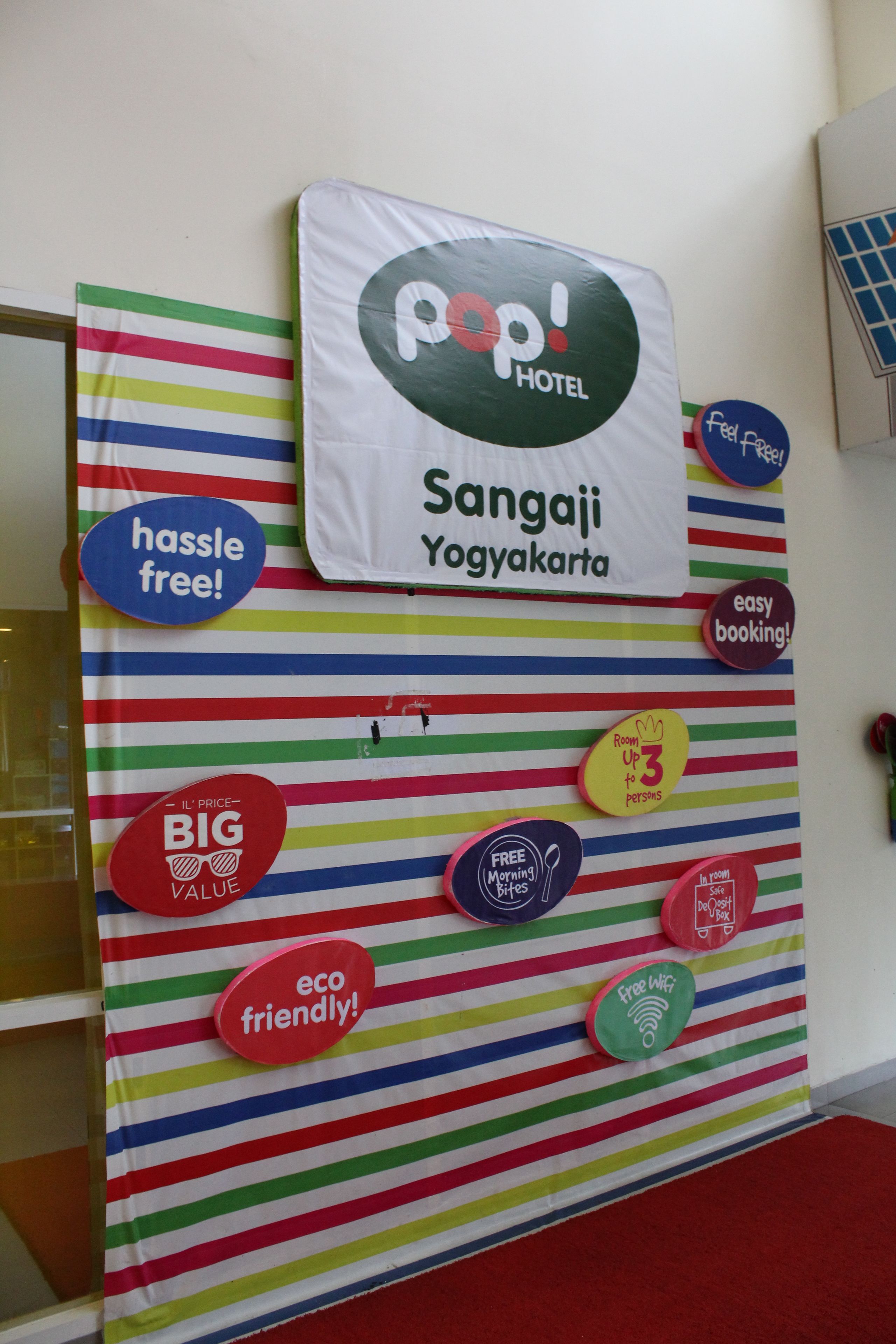 A colorful wall with various signs indicating features such as 'hassle free', 'eco friendly', and 'free WiFi'.