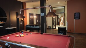 A billiards table with a pool cue rack and two overhead lamps.