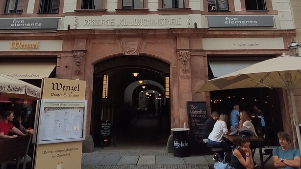A historic building with a central archway, multiple windows, and a sign for 'Passage KL. JOACHIMSTHAL'.