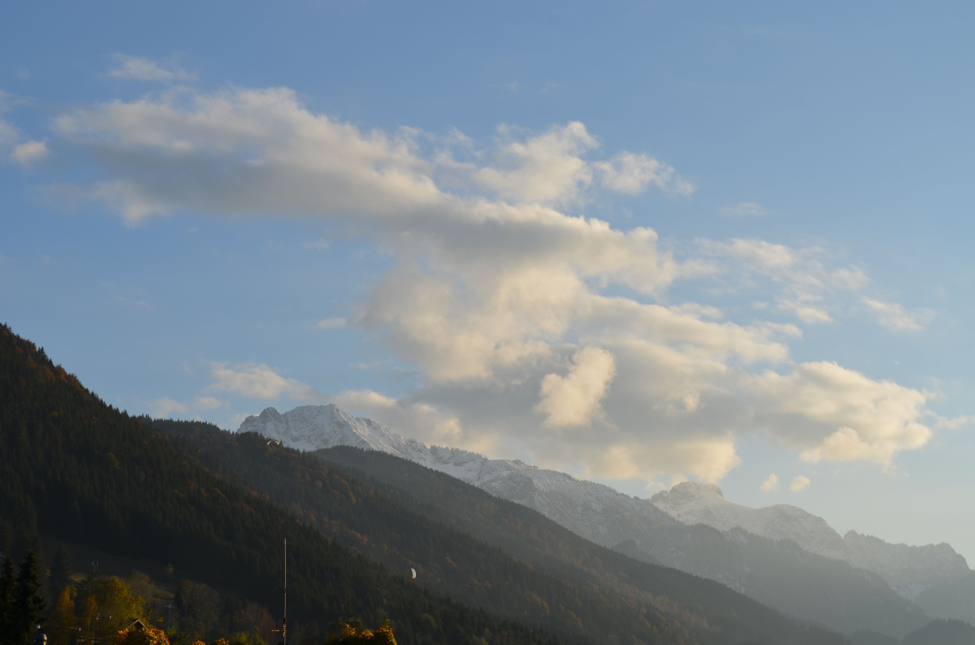 A mountainous landscape with snow-capped peaks and a clear sky.