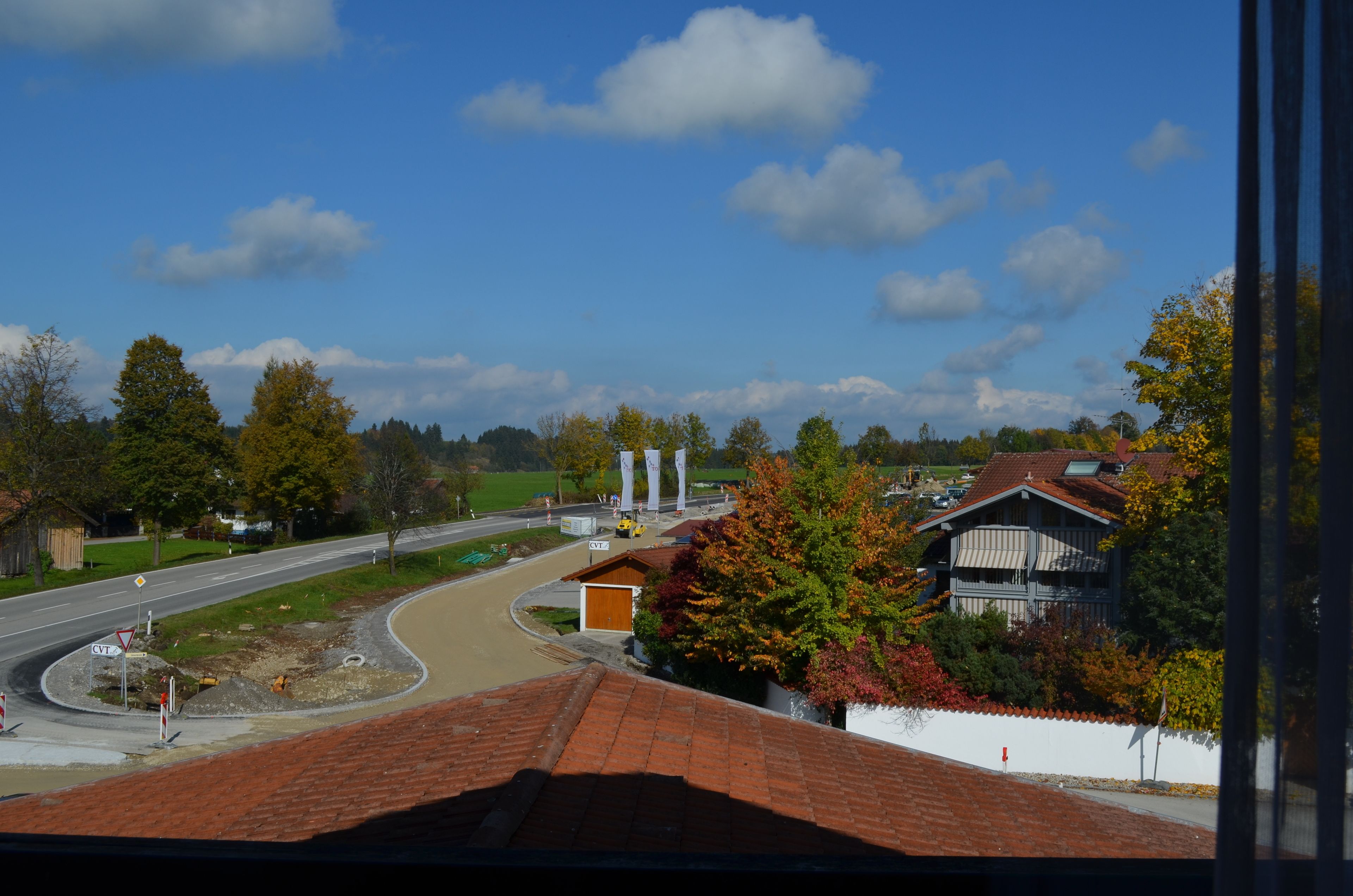A view of a road curving through a residential area with houses and trees.