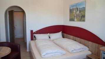 Un dormitorio con cama, una silla y un cuadro en la pared.