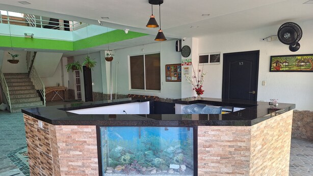 A modern kitchen with a central island, a staircase, and a large window.
