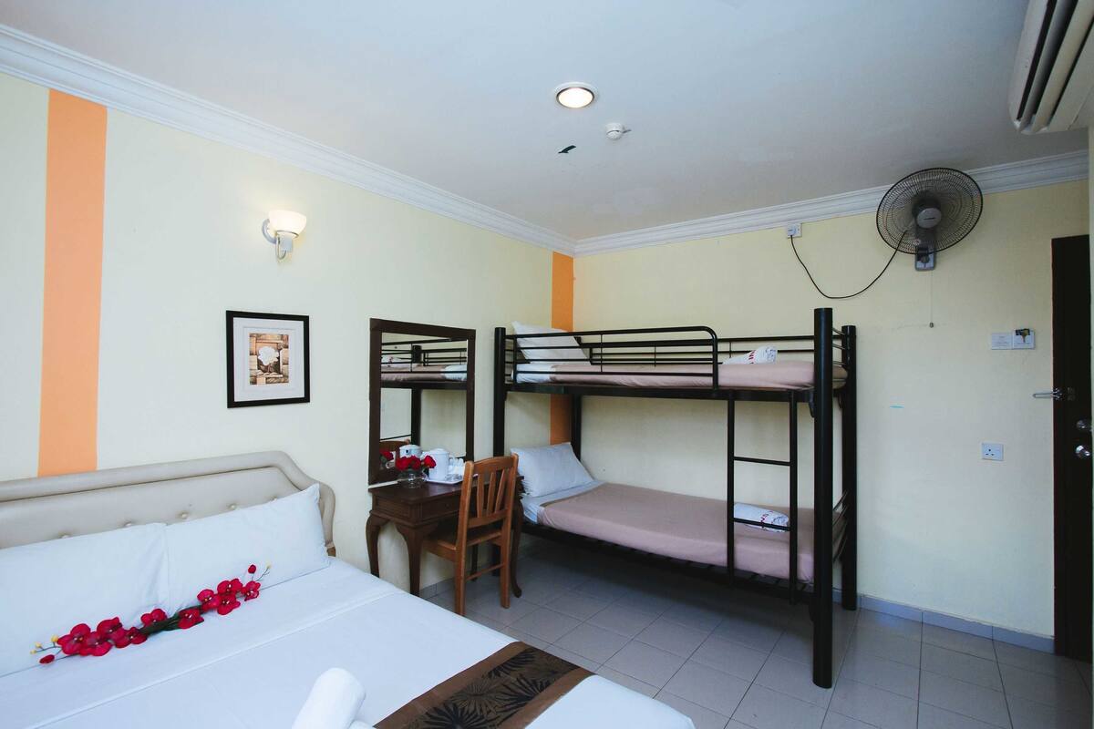 Een kamer met stapelbedden, een bureau, een stoel en een bed.