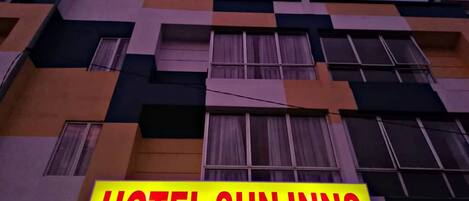 Um edifício com uma placa que diz 'HOTEL SUN INNS'.