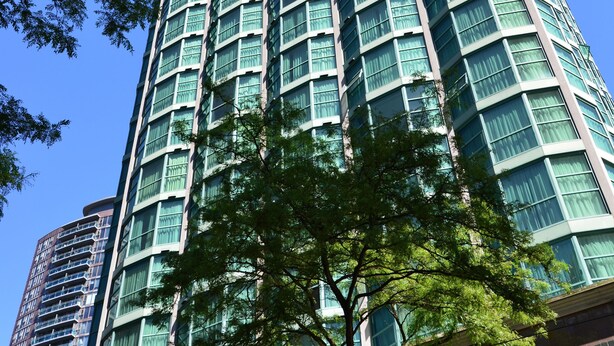 A tall, modern building with a grid of windows and a central entrance. - Rosedale Condominiums (Vancouver)
