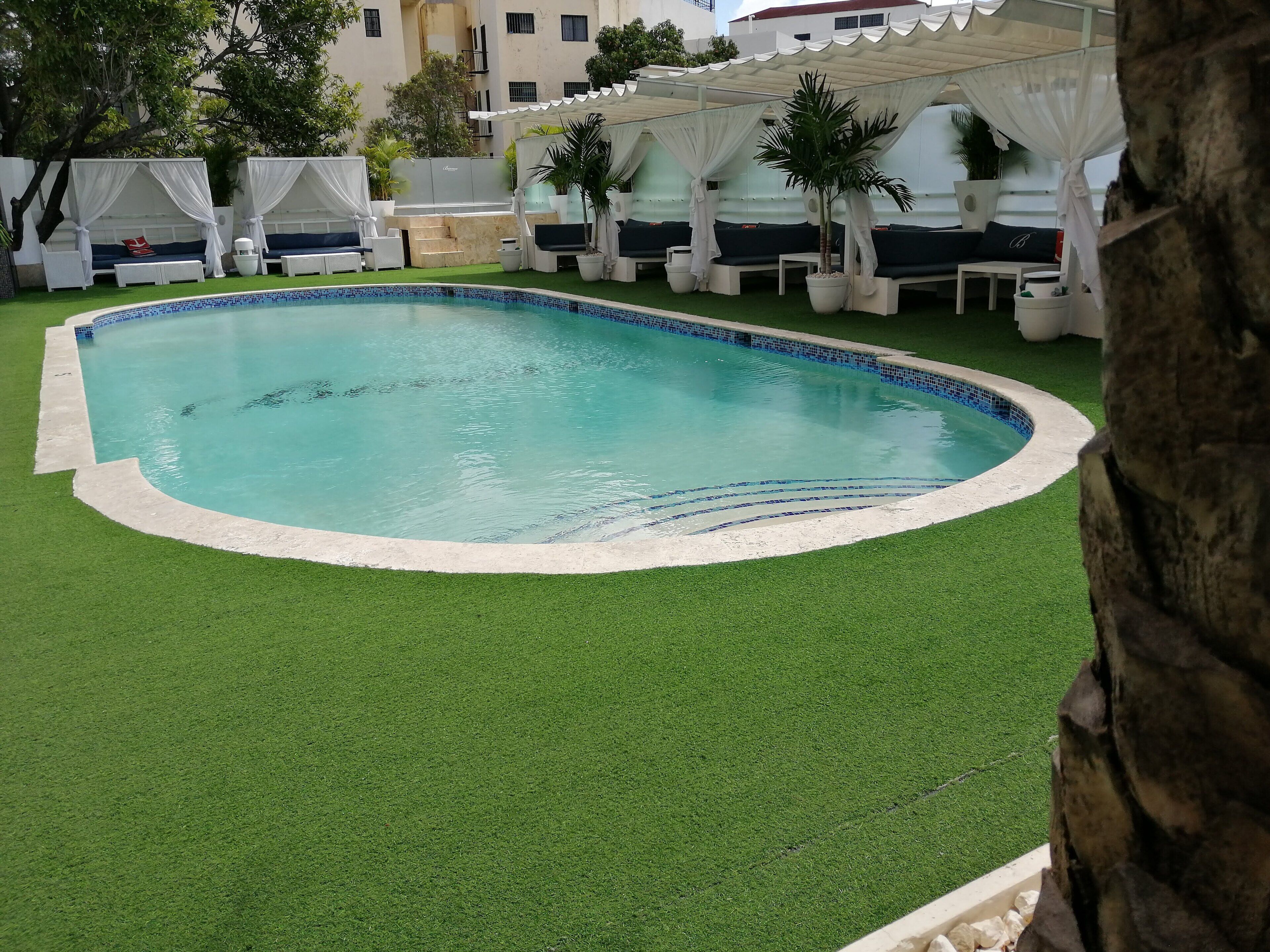 Una piscina al aire libre, sombrillas, tumbonas