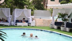 Una piscina con sillones de descanso y un área de tumbonas.