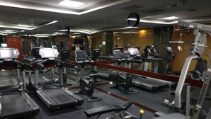 Un gimnasio con cintas de correr, elípticas y equipo de pesas.