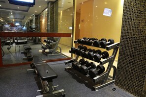 A gym with exercise equipment, including dumbbells and a bench.