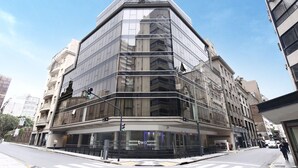 A modern building with a glass facade and a corner entrance. - Two Hotel Buenos Aires (Buenos Aires)