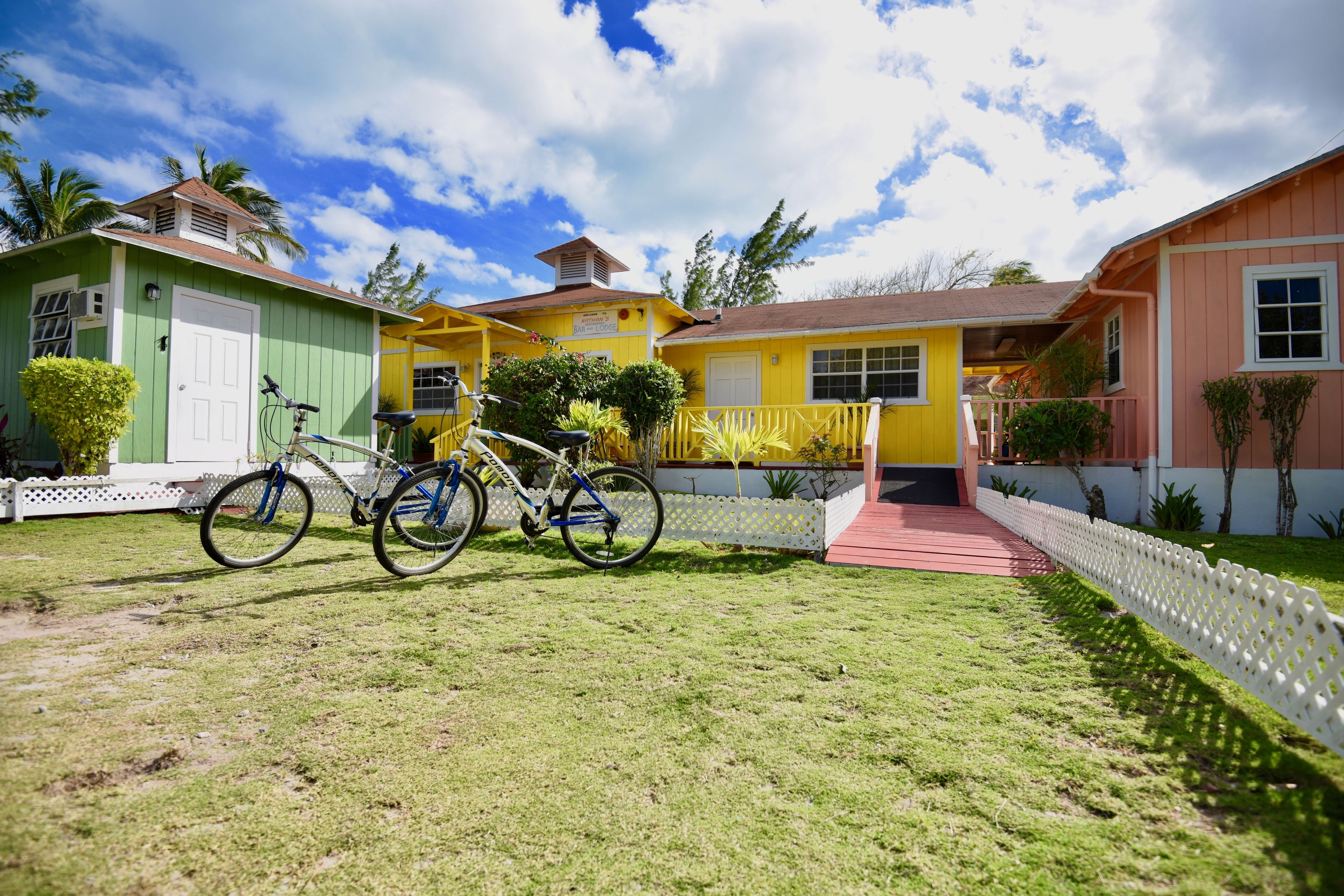 A residential area with two houses, one green and one yellow, with a bicycle parked in front.