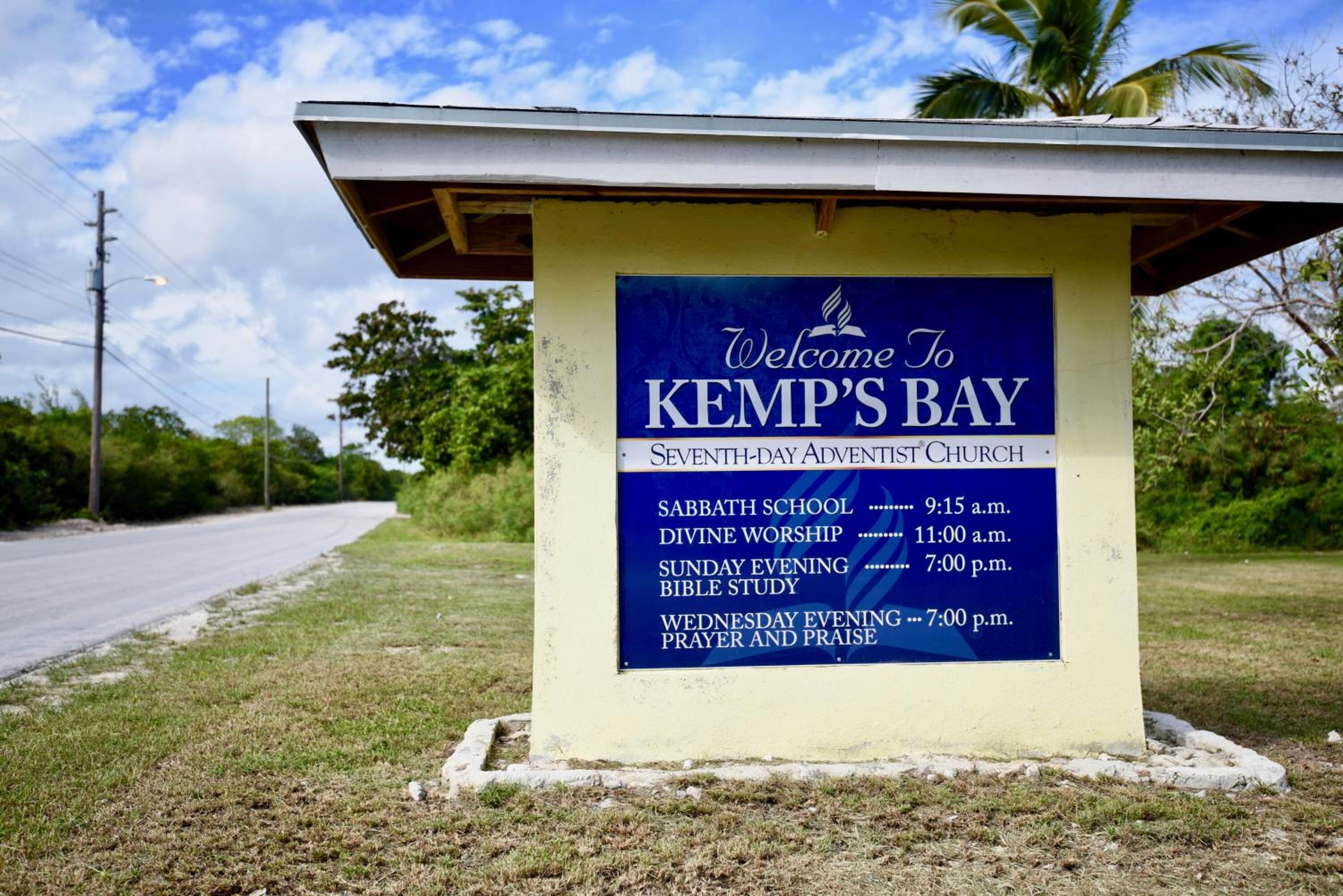 A signboard for Kemp's Bay Seventh-Day Adventist Church listing various events and times.