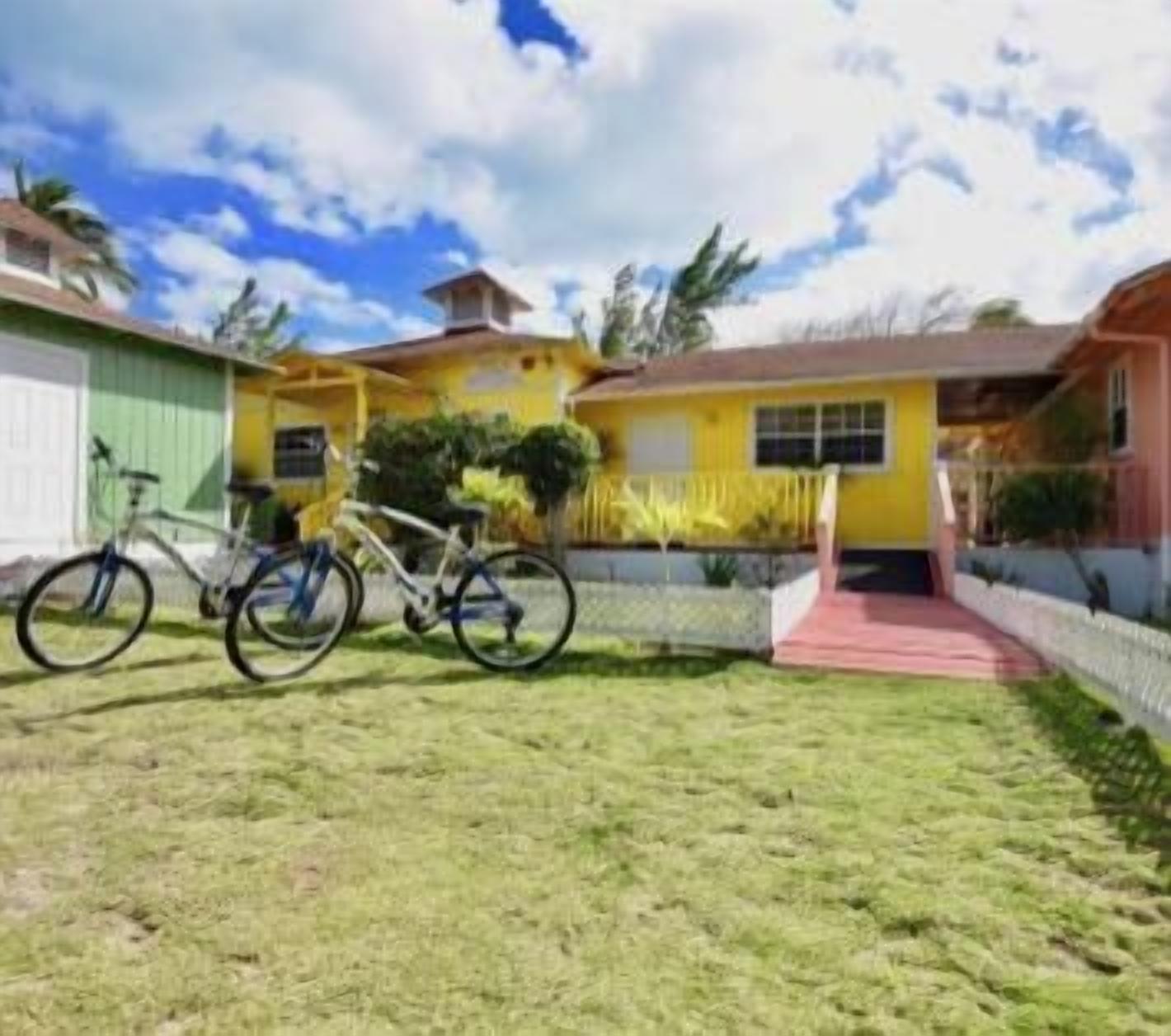 Una propiedad residencial con jardín delantero, una bicicleta y un sendero rojo que conduce a la entrada.