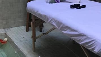 Relax in a serene spa setting with a comfortable bed and a hot tub.
